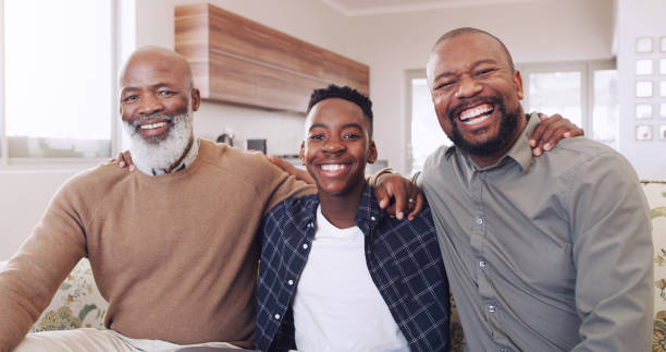 Three generations and proud Cropped portrait of a young boy sitting on the sofa and bonding with his father and grandfather grandson photos stock pictures, royalty-free photos & images