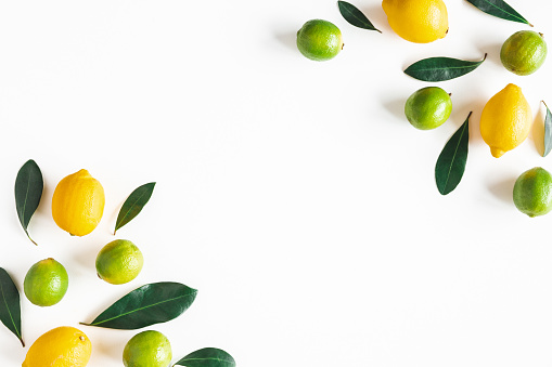 Lemon and lime fruits on white background. Flat lay, top view