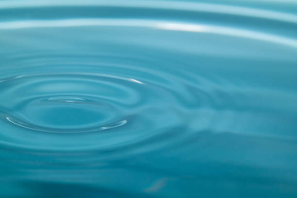 istock Closeup Water drop falling on the surface of the water and beautiful circular wave ripple, fresh natural mineral water drink water concept 1210030249