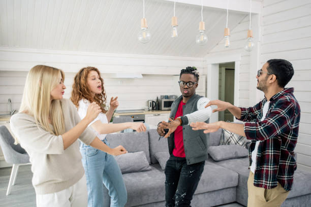 istock Two young intercultural couples enjoying dancing together in living-room 1210030451