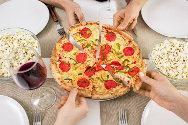 istock Hands of young friends taking slices of appetizing pizza while having lunch 1210030461