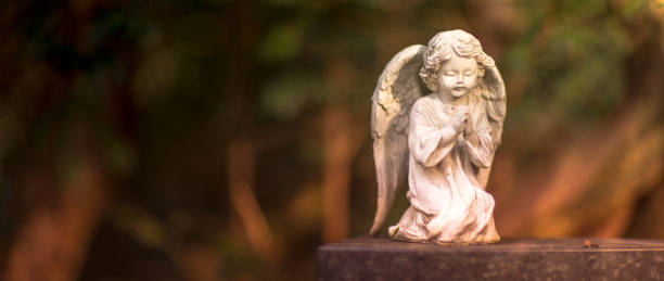 istock white angel figure on tombstone 1210031477