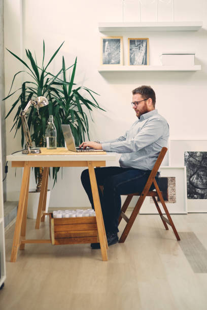 istock Young male architect sitting at his desk and typing. 1210036089
