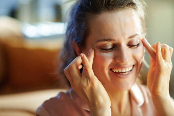 istock smiling modern middle age housewife applying eye cream 1210038763