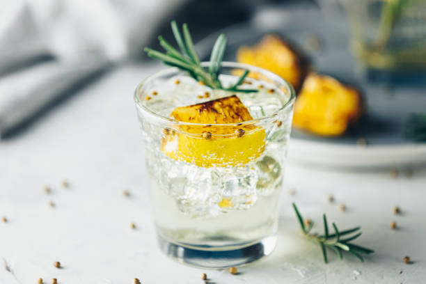 Charred Lemon, Rosemary and Coriander Gin and Tonic is a flavors are perfectly balanced refreshing cocktail. on light background, close up. Summer drinks and alcoholic cocktails stock photo
