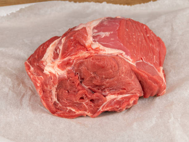 raw beef clod on white wrapping paper closeup