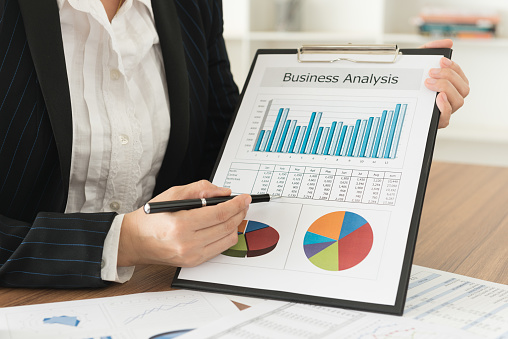 Business financial data analysis concept. Business woman presenting the chart and graph showing the results of project her team successful.