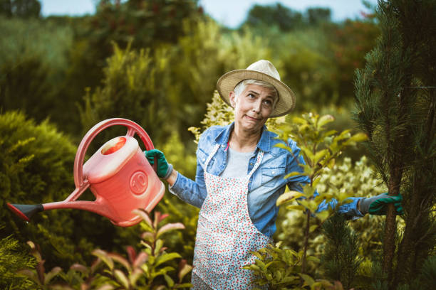 istock Mature woman making a face while watering her plants in the backyard. 1210043129