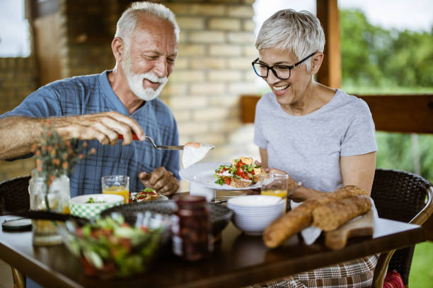 istock Happy mature couple having breakfast on a balcony. 1210043424