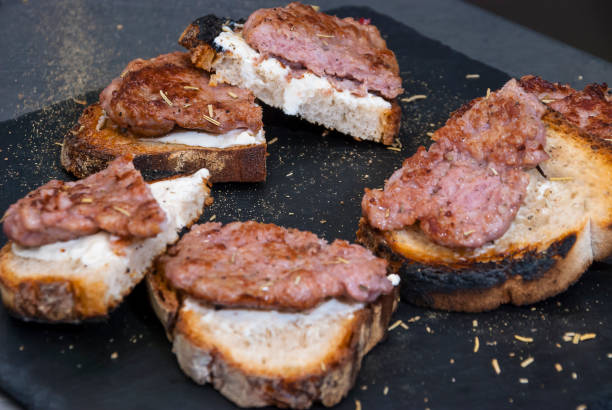 istock Grilled sausages with bread on black plate 1210044430