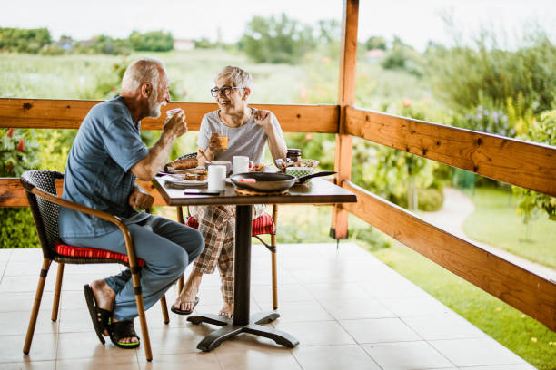 istock Happy mature couple talking while having breakfast on a balcony. 1210044580