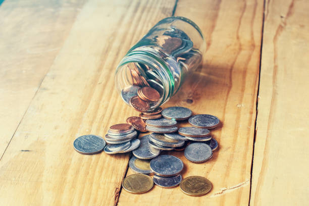 istock Saving money in glass jar on wood background. 1210046487