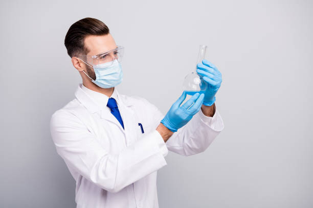 istock Close-up profile side portrait of his he nice attractive focused skilled experienced doc scientist making analysis lab center holding bulb in hands isolated on light white gray pastel color background 1210047494