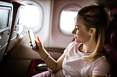 junge-frau-mit-handy-in-einem-flugzeug.j