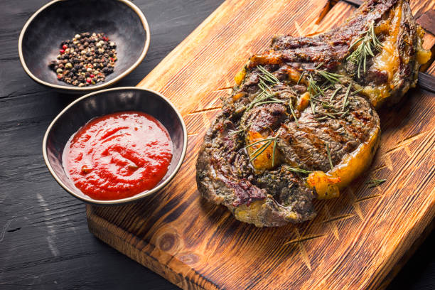 istock Juicy medium rare beef steak on board with herbs spices and salt. 1210051504