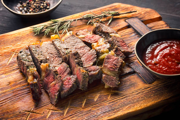 istock Juicy medium rare beef steak on board with herbs spices and salt. 1210051533