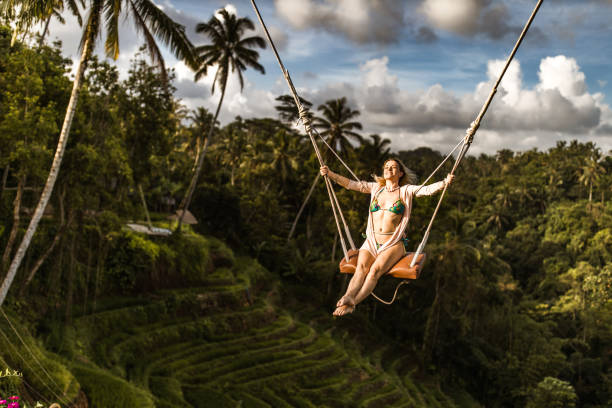 istock Happy woman having fun on a swing above the rainforest. 1210051593