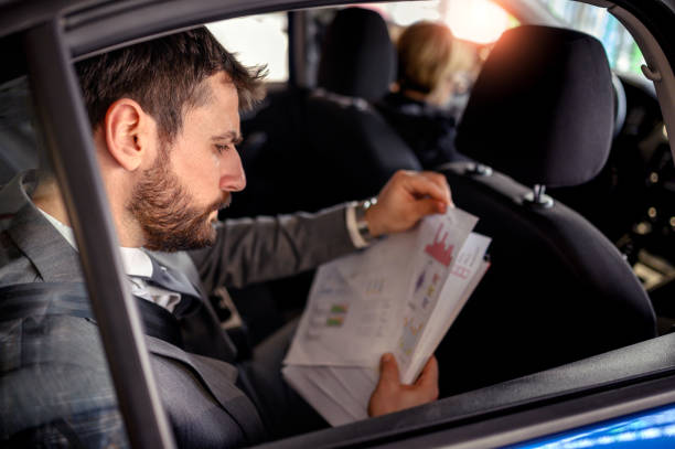 istock Businessman working in back seat of car 1210051965