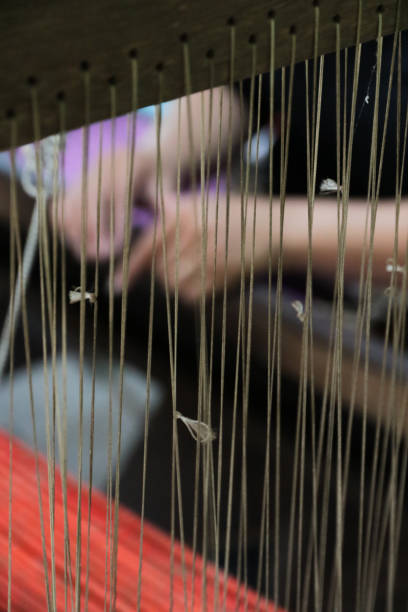 istock woman weaving silk on loom 1210052612
