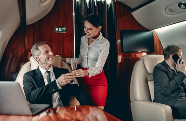 stewardess und geschäftsmann im privatjet - vehicle interior corporate jet jet private airplane stock-fotos und bilder