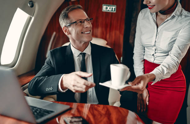 stewardess und geschäftsmann im privatjet - vehicle interior corporate jet jet private airplane stock-fotos und bilder