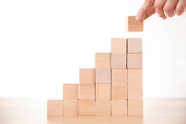 istock Hand Arranging Wood Block Stacking as  Step Stair or Bar Graph 1210052912