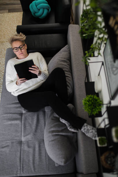 istock Young woman with tablet pc on the sofa 1210052932