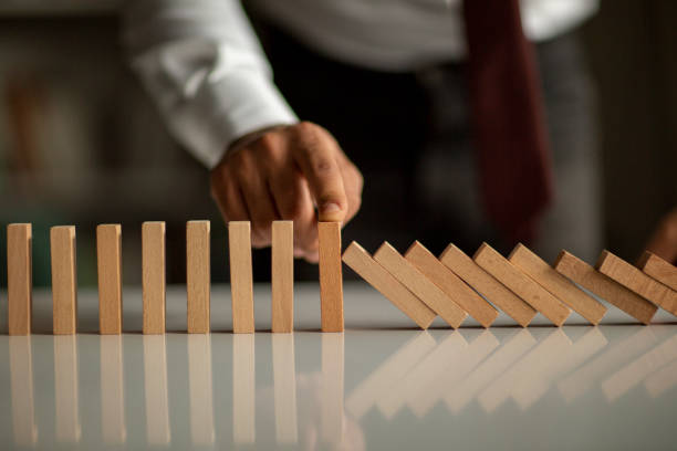 istock Businessman Stop Domino Effect. Risk Management and Insurance Concept 1210053025