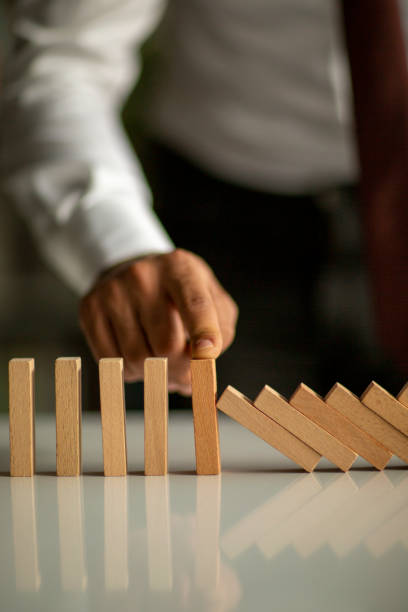 Businessman Stop Domino Effect. Risk Management and Insurance Concept