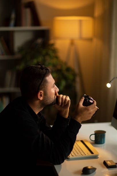 istock Cheerful man checking pictures on camera at home 1210054086