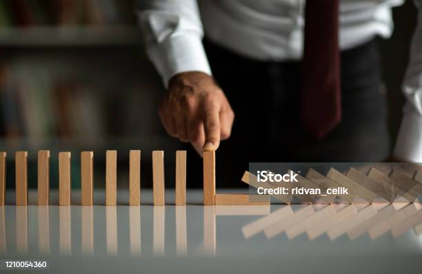 Businessman Stop Domino Effect Risk Management And Insurance Concept Stock Photo - Download Image Now