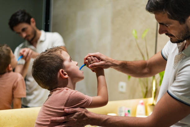 istock Father and son brushing teeth in bathroom 1210054680