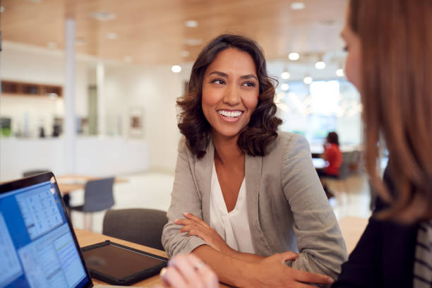 istock Two Businesswomen With Laptop At Desk In Open Plan Office Collaborating On Project Together 1210054736