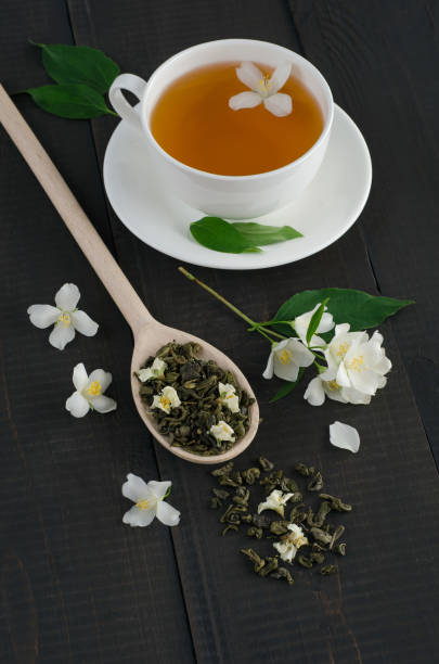 ジャスミンの花とお茶の便利なカップ - tea tea leaves jasmine tea leaf ストックフォトと画像