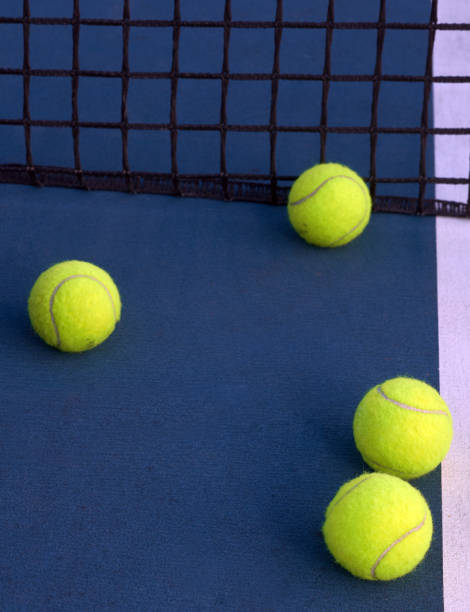 pelotas de tenis bajo red en la pista - let deporte de raqueta fotografías e imágenes de stock