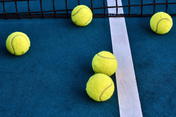 pelotas de tenis bajo red en la pista - let deporte de raqueta fotografías e imágenes de stock