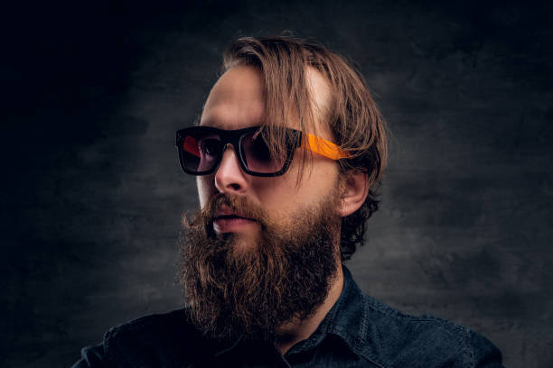 istock Attractive bearded man in sunglasses over dark background. 1210058603