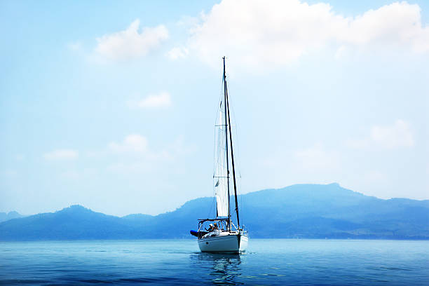 Splendid view of sailboat sailing near the cliffs of  Santa Teresa Gallura. Popular travel destination of Mediterranean sea. Location: Santa Teresa Gallura, Province of Sassari, Sardinia, Italy, Europe
