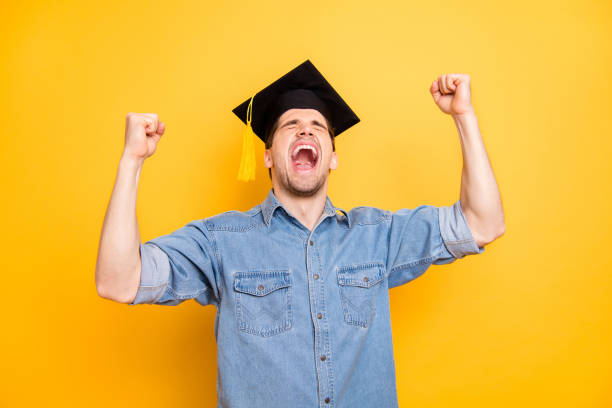 Portrait of his he nice attractive funky cheerful cheery glad guy celebrating, getting master degree specialist scientist isolated over bright vivid shine vibrant yellow color background