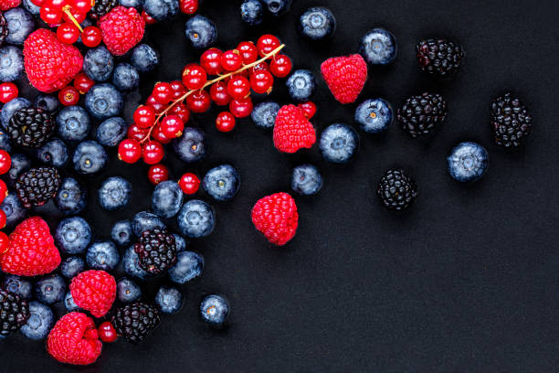 istock Various fresh forest berries on black stone background, top view. Berry mix. Flat lay. Copyspace 1210061940
