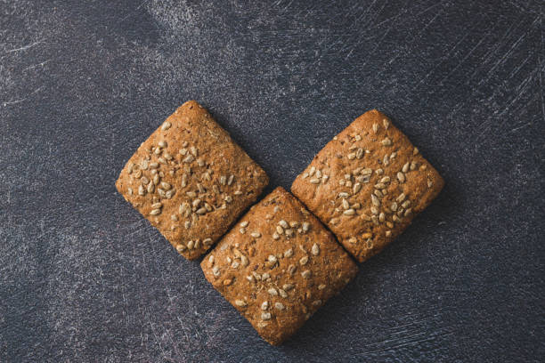 Baked pastry item with sunflower seeds Fresh baked pastry items with sunflower seeds isolated on dark background vitamin b 3 stock pictures, royalty-free photos & images