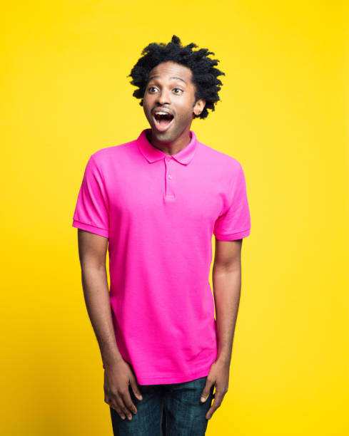 retrato colorido de jovem animado vestindo camisa polo rosa - polo shirt african ethnicity men african descent - fotografias e filmes do acervo