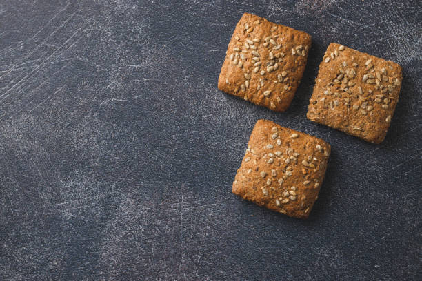 Baked pastry item with sunflower seeds Fresh baked pastry items with sunflower seeds isolated on dark background vitamin b 3 stock pictures, royalty-free photos & images