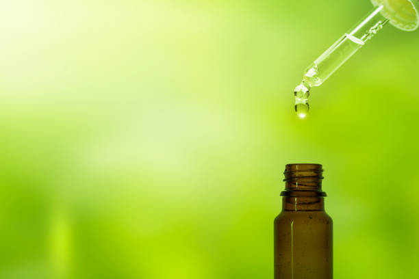 新鮮な緑色の背景にピペットの茶色の薬のフィアルにドロップ - drop defocused focus on foreground herbal medicine ストックフォトと画像