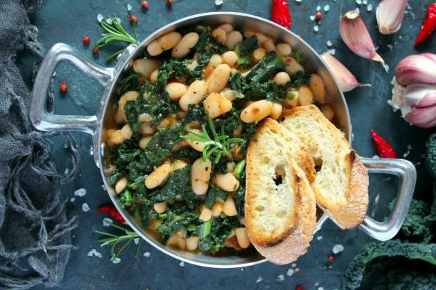 istock Stewed beans with black cabbage served with toasted bread. 1210069898