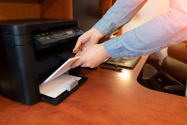 istock Human hand is reloading the paper to printer tray 1210071731