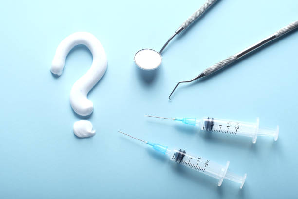 istock Dental care concept with a question mark. Syringes and endodontic instruments on blue. 1210071964