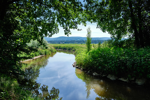 Beautiful scenic view in a landscape near the town Alzenau, Bavaria, Germany, with the river Kahl an the hills of the Spessart in the background