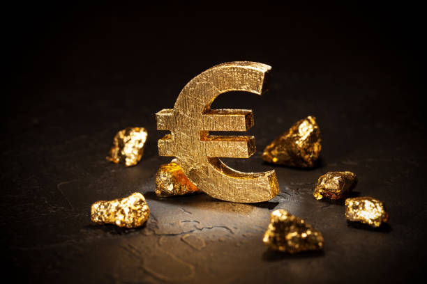 istock Gold euro sign and gold nuggets on black background. 1210080342