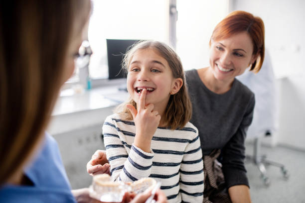 a small girl, mother and dentist in surgery, dental checkup. - dentist surgery dental hygiene using voice imagens e fotografias de stock